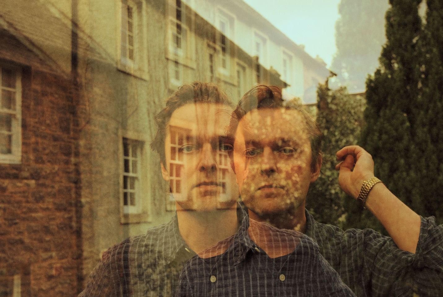 Joshua Burnside wearing a blue check shirt and gold watch